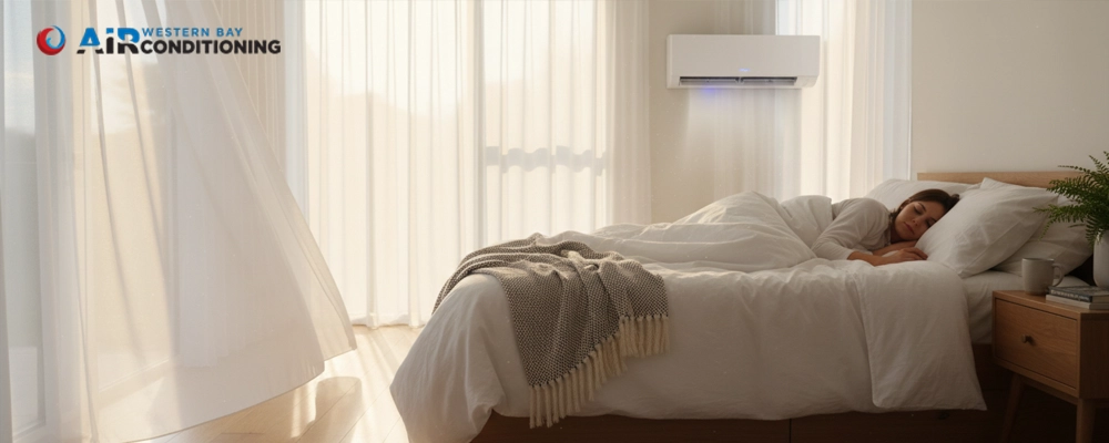 Woman sleeping in a bright bedroom with a wall-mounted heat pump, showing how air conditioning can support cleaner air, comfort, and healthier sleep at home.